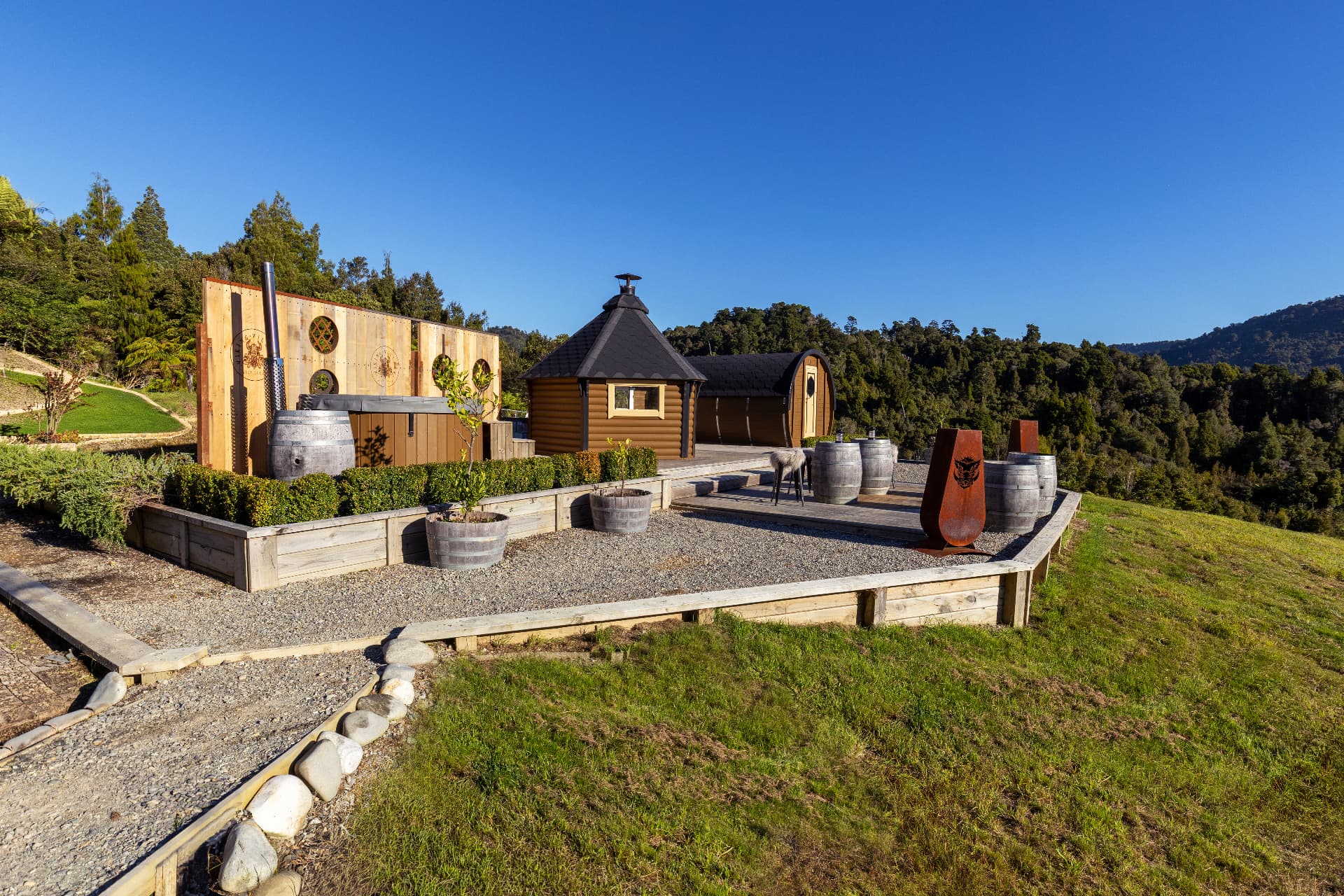 Viking Village barrel cabins, spa and grill hut on a sunny ridge above native bush